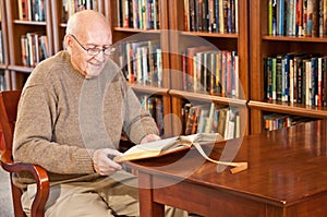 Uomo un lettura un libro sul biblioteca tavolo 