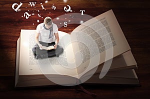 Man sitting and reading inside book