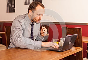 Man sitting in restaurant with laptop,and phone