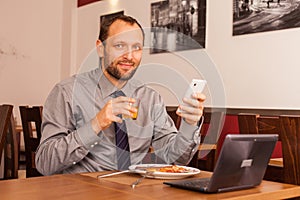 Man sitting in restaurant with laptop,and phone