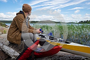 Man sitting on the riverside resting after active paddling