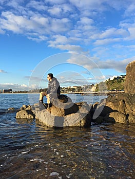 Man sitting on rocks on beach