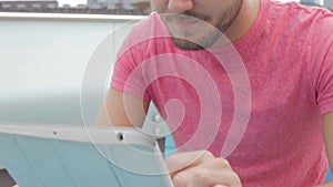 Man Sitting On Roof Terrace Using Digital Tablet