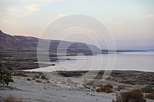 A man is sitting on the shore of the Dead Sea A man sitting yoga in tropical island with blus sky and blues gradient