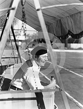 Man sitting on the sideline of a tennis court enjoying a game