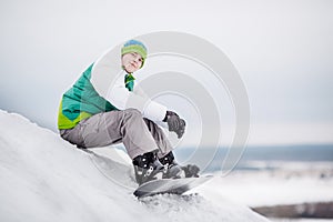 Man sitting on the snow with snowboard