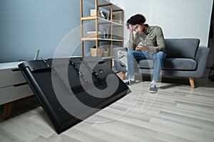 Man Sitting On Sofa In Front Fallen Television