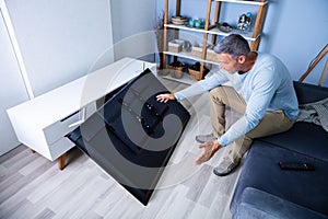 Man Sitting On Sofa In Front Fallen Television