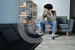 Man Sitting On Sofa In Front Fallen Television