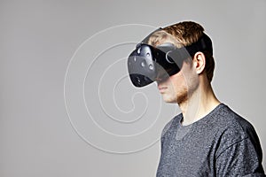 Man Sitting On Sofa At Home Wearing Virtual Reality Headset