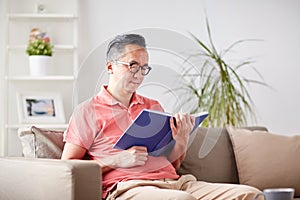 Man sitting on sofa and reading book at home