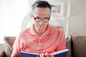 Man sitting on sofa and reading book at home