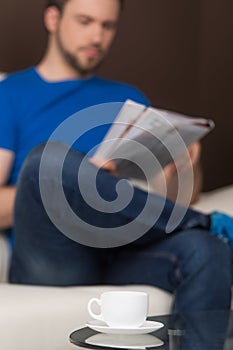 Man sitting on sofa relaxed and reading.