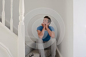 Man sitting on stairs looking anxious