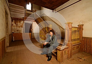 Man Sitting on Stairs in an Old House