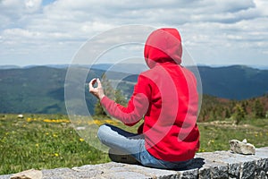 Man sitting on stoned wall mediting and looking the mountain landscape