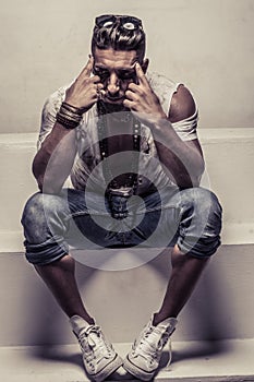 Man Sitting on Studio Steps with Head in Hands