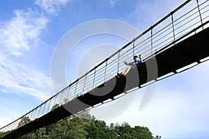 Man sitting on suspension bridge over Belaya River