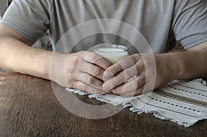 Man sitting at the table with glass of kefir in his hands