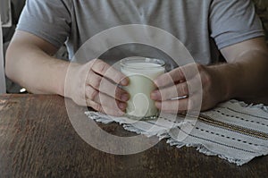 Man sitting at the table with glass of kefir in his hands