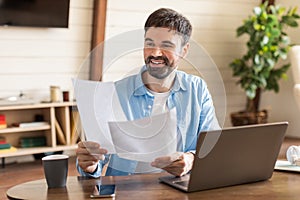 Man Sitting at Table Holding Piece of Paper