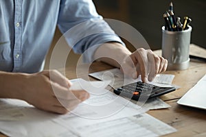 Man sitting at table using calculator calculates costs manage budget