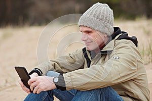 Man sitting with tablet on the winter beach