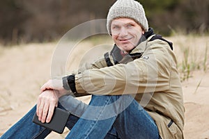 Man sitting with tablet on the winter beach