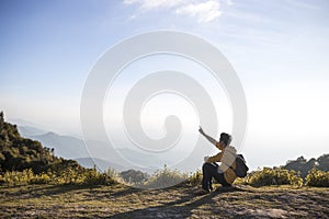 A man sitting on top of mountain.