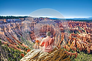 Man sitting on top of the mountain looking at beautiful view