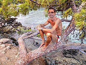 Man sitting on tree - Phaselis bay - Ã‡amyuva, Kemer, coast and beaches of Turkey