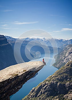 Man sitting on trolltunga rock in norway