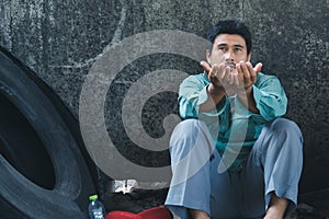 A man sitting by a wall