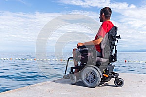 Man sitting in a wheelchair on the beach