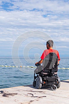 Man sitting in a wheelchair on the beach