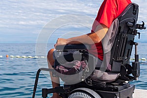 Man sitting in a wheelchair on the beach
