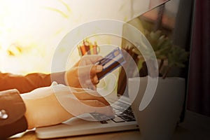 Man sitting wood table and using notebook with credit card for online payment, Man`s hands holding a credit card and using laptop