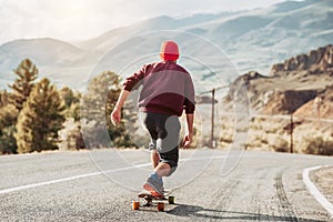 Man skateboarding at mountain road photo