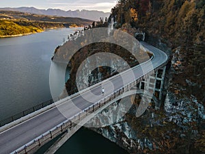 Man skates over a bridge on the lake in autumn
