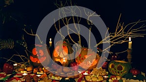 Man, skeleton, lights candles in Halloween monster pumpkins