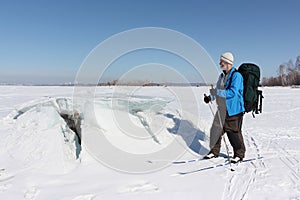 Man on ski looking at the ice breaking on the river