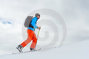 Man with ski mountaineering climb towards the summit