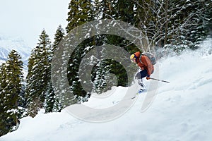 Man skier rides freeride on powder snow in forest