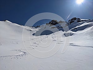 Man skier rides through powder snow to the mountains. Winter sports freeride. Etscherzapfen in Glarus Swiss, Skimo