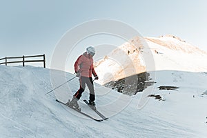Man skier riding by snowy piste