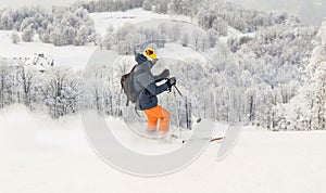Man skier skiing downhill on ski slope
