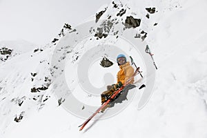 Man skier with skitour equipment is rest on the snowy hill photo