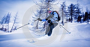 Man skiing in powder snow in a snowy woods.