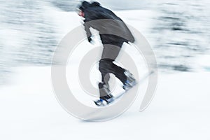 A man skiing snow board very fast. blurred picture.