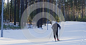 Man skiing on snowy slope amidst trees in forest